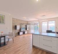 Helles Wohnzimmer in einer 2-Zimmer-Wohnung mit Holzboden und Kücheninsel.