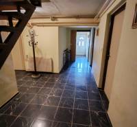Innenraum mit schwarzen Wandfliesen und Treppe in einem Einfamilienhaus.
