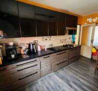Küche mit schwarzen Schränken und Holzboden in einem Einfamilienhaus.