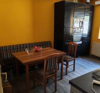 Esszimmer in einem Einfamilienhaus mit Holztisch, Stühlen und Boden mit Holzdekor.
