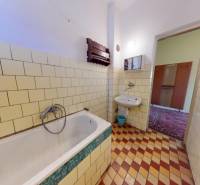 Ein Badezimmer in einem Einfamilienhaus mit Fliesen und einer Badewanne.