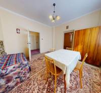 Wohnzimmer in einem Einfamilienhaus mit Teppich, Tisch, Sofa und Schrank.