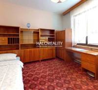 Ein Zimmer mit Teppichboden, Holzmöbeln in einem Einfamilienhaus.