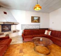 Wohnzimmer mit Kamin und Sofa in einem Einfamilienhaus, mit Holzboden.