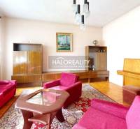 Wohnzimmer in einem Einfamilienhaus mit Teppichmuster und Holzboden.