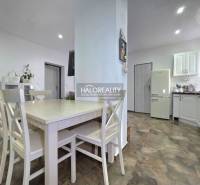 Küche in einem Einfamilienhaus mit Holzboden und weißen Möbeln.