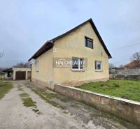 Ein Einfamilienhaus in Čereňany mit Garage, grünem Rasen und Zufahrtsweg.