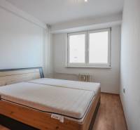 Schlafzimmer mit Bett und Holzboden in einer 2-Zimmer-Wohnung.