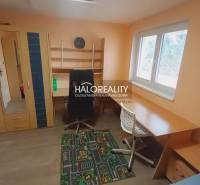 Ein Zimmer in einem Einfamilienhaus mit einem Boden in Holzoptik, einem Schrank und einem Schreibtisch.