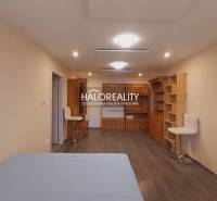 Ein Zimmer in einem Einfamilienhaus mit einem Boden in Holzoptik und Holzmöbeln.