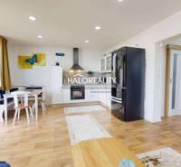 Küche in einer 3-Zimmer-Wohnung mit Holzboden, Esstisch und modernen Geräten.