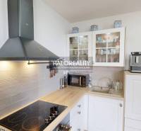 Küche in einer 3-Zimmer-Wohnung mit Kochfeld und Schränken mit Glastüren.