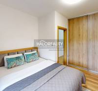 Schlafzimmer in einer 3-Zimmer-Wohnung mit Bett und Einbauschrank, Boden mit Holzdekor.