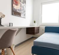Arbeitsbereich in einer 4-Zimmer-Wohnung mit Sofa und Tisch auf hellem Boden.