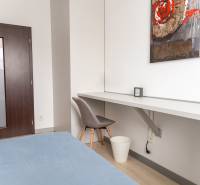 Ein Zimmer in einer 4-Zimmer-Wohnung mit einem Boden in Holzoptik, einem Tisch und einem Sessel.