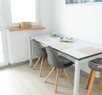Essbereich mit Tisch und Stühlen in einer 4-Zimmer-Wohnung, Boden mit Holzdekor.