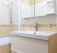 Badezimmer mit Duschkabine, Spiegelschrank und Waschbecken in einer 4-Zimmer-Wohnung.