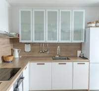 Küche in einer 4-Zimmer-Wohnung mit Holzboden und weißen Schränken.