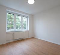 Helles Zimmer mit weißen Wänden und einem Boden in Holzoptik in einer 3-Zimmer-Wohnung.