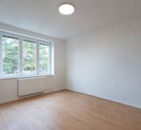 Ein geräumiges Zimmer mit einem großen Fenster und einem Boden in Holzoptik in einer 3-Zimmer-Wohnung.