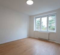 Geräumiges Zimmer mit großem Fenster und Holzboden in einer 3-Zimmer-Wohnung.