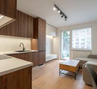 Wohnzimmer in einer 3-Zimmer-Wohnung mit Küchenzeile und Holzboden.