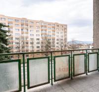 Der Balkon einer 3-Zimmer-Wohnung in Dubnica nad Váhom mit Blick auf ein Wohngebäude und Grünflächen.