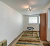 Ein schmaler Raum mit Teppichboden, Tischfußball und Möbeln in einer 3-Zimmer-Wohnung.