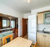 Küche in einer 3-Zimmer-Wohnung mit Durchgang zum Wohnzimmer und einem Boden mit Holzdekor.