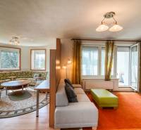 Wohnzimmer in einer 3-Zimmer-Wohnung mit einem bequemen Sofa und einem Boden in Holzoptik.