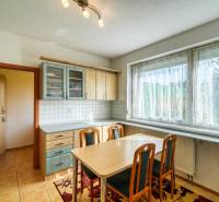 Küche in einer 3-Zimmer-Wohnung mit Esstisch, Boden in Holzoptik und großem Fenster.