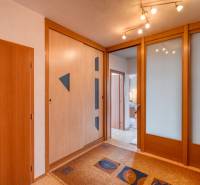 Der Flur in der 3-Zimmer-Wohnung mit Holzelementen und einem Einbauschrank.