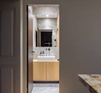 Badezimmer mit grauen Fliesen und Waschbecken in einer 4-Zimmer-Wohnung, Boden mit Holzdekor.