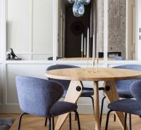 Ein runder Tisch mit blauen Stühlen und hängenden Leuchten in einer 4-Zimmer-Wohnung mit Holzboden.