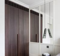 Schlafzimmer in einer 4-Zimmer-Wohnung mit Holzboden und einem Kleiderschrank aus dunklem Holz.