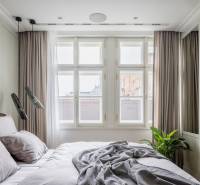 Schlafzimmer in einer 4-Zimmer-Wohnung mit großen Fenstern, Fernseher und neutralen Farben.