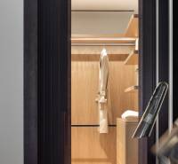 Ein Kleiderschrank mit heller Verkleidung, Kleiderbügel und Beleuchtung in einer 4-Zimmer-Wohnung.