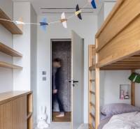 Ein Kinderzimmer mit einem Etagenbett, Holzmöbeln und Spielzeug in einer Vierzimmerwohnung.