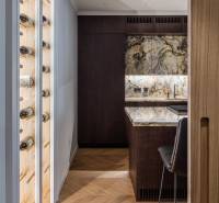 Küchenecke mit Holzboden und einer Glaswand für Wein in einer 4-Zimmer-Wohnung.