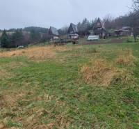 Weitläufige Erholungsgrundstücke in Púchov mit Hütten und von Bäumen gesäumtem Grün.