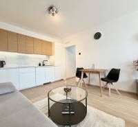 Küche in einer Einzimmerwohnung mit Holzboden und bequemen Sitzgelegenheiten.