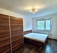 Schlafzimmer mit Schrank, Bett und Boden in Holzoptik in einer 4-Zimmer-Wohnung.