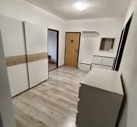 Ein Flur mit weißen Möbeln und einem Boden in Holzoptik in einer 4-Zimmer-Wohnung.
