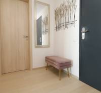Flur in einer 2-Zimmer-Wohnung mit einem Boden in Holzoptik und einer Bank.