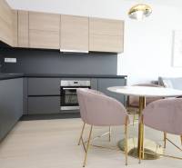 Küche in einer 2-Zimmer-Wohnung mit Holzboden und stilvollem Tisch.