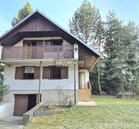 Eine Hütte in Borský Svätý Jur, umgeben von Grün und Bäumen, mit einem Holzbalkon.