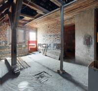 Ein ungenutzter Dachbodenraum mit Holzbalken in einem Einfamilienhaus.