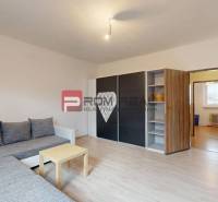 Wohnzimmer in einem Einfamilienhaus mit Sofa, Schrank und Tisch, Boden mit Holzdekor.