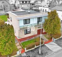 Ein Einfamilienhaus in Martin mit Flachdach, Garten und umliegenden Häusern.