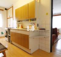 Küche in einem Einfamilienhaus mit Holzboden, verbunden mit dem Wohnzimmer.